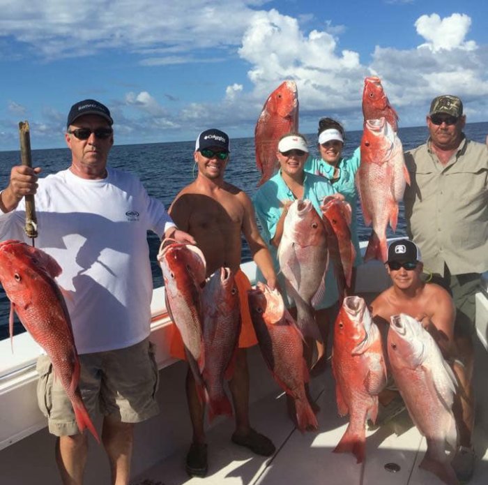 Apalachicola Fishing Company group holding red snappers