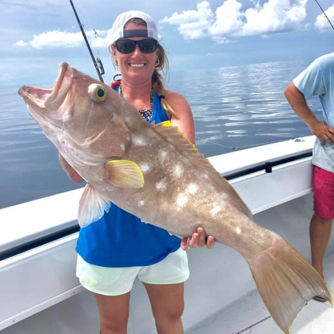 Woman holding her catch that was caught with the Apalachicola Fishing Company