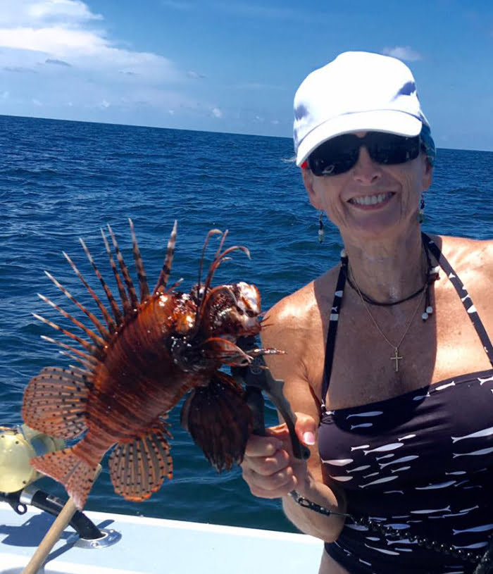 Woman holding her lion fish catch